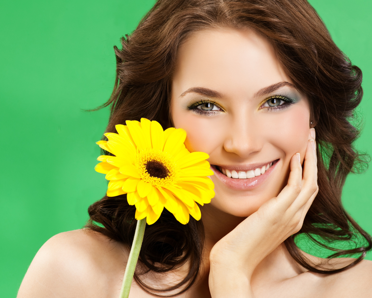 Девушка с красивой улыбкой и цветком желтой герберы в руках