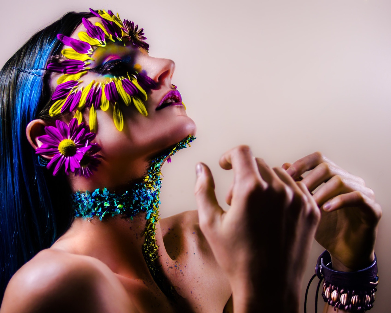 Девушка с украшенным лепестками цветов лицом и ярким макияжем