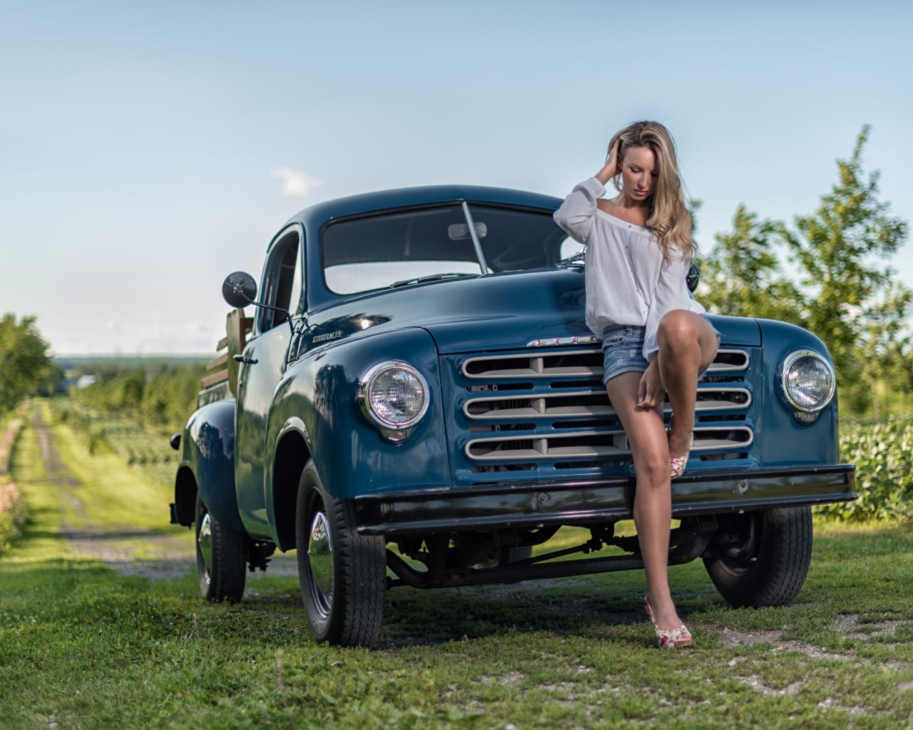 Молодая девушка стоит рядом с зеленым автомобилем Studebaker Pickup, 1953 года