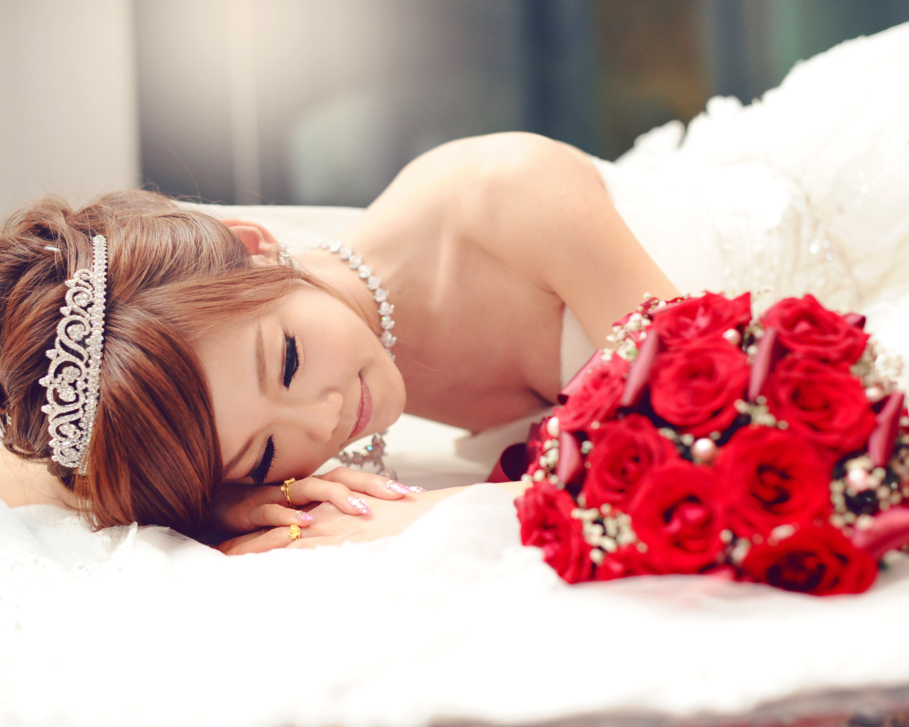Красивая девушка азиатка в свадебном платье с букетом красных роз