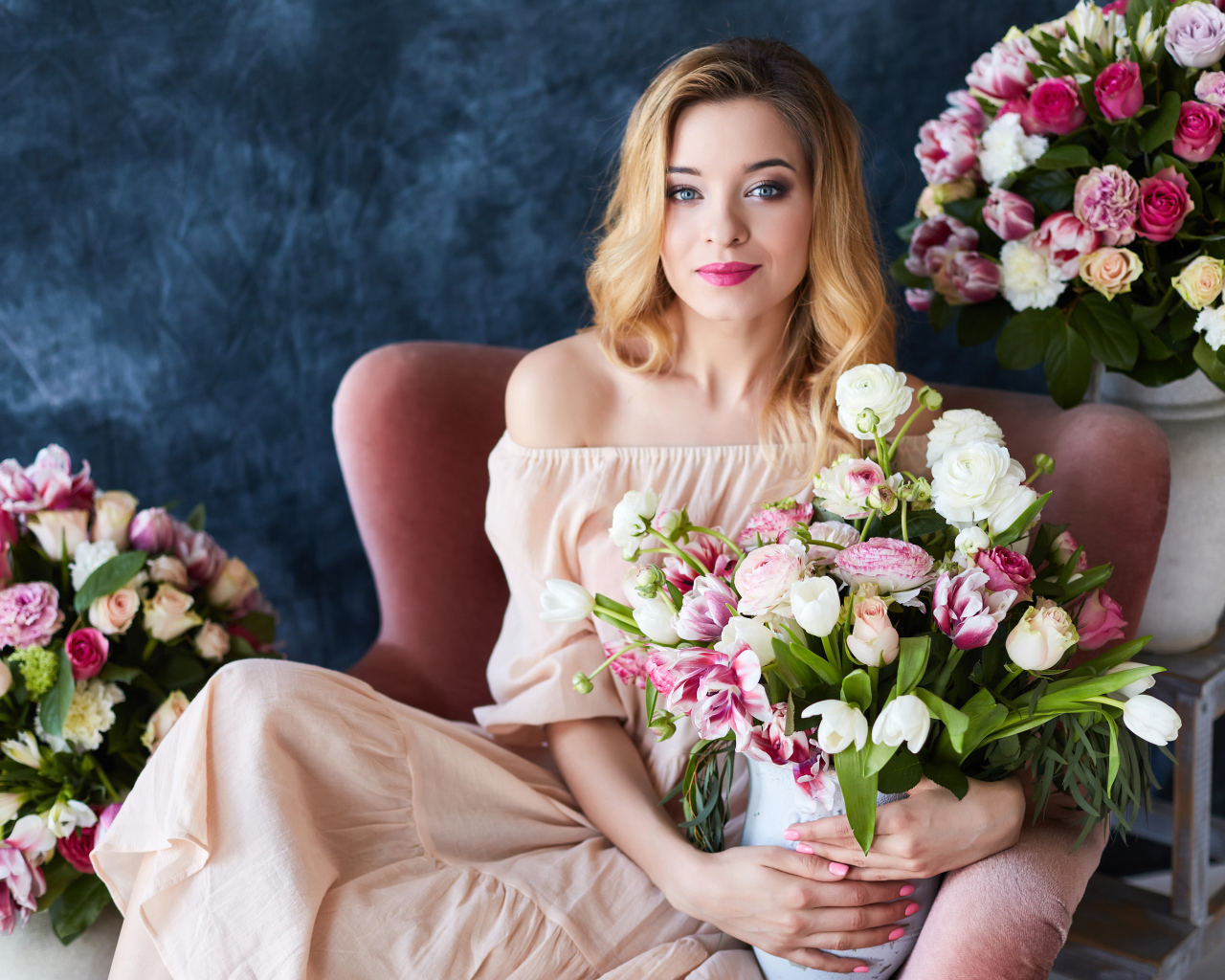 Красивая девушка блондинка сидит с букетом цветов
