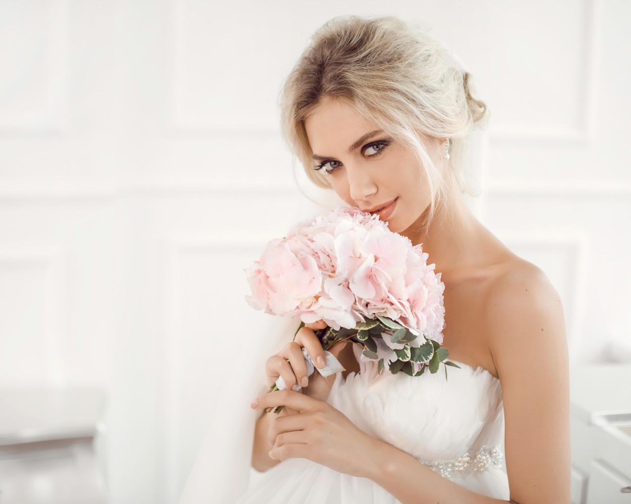 Красивая блондинка невеста с букетом розовых цветов в руках