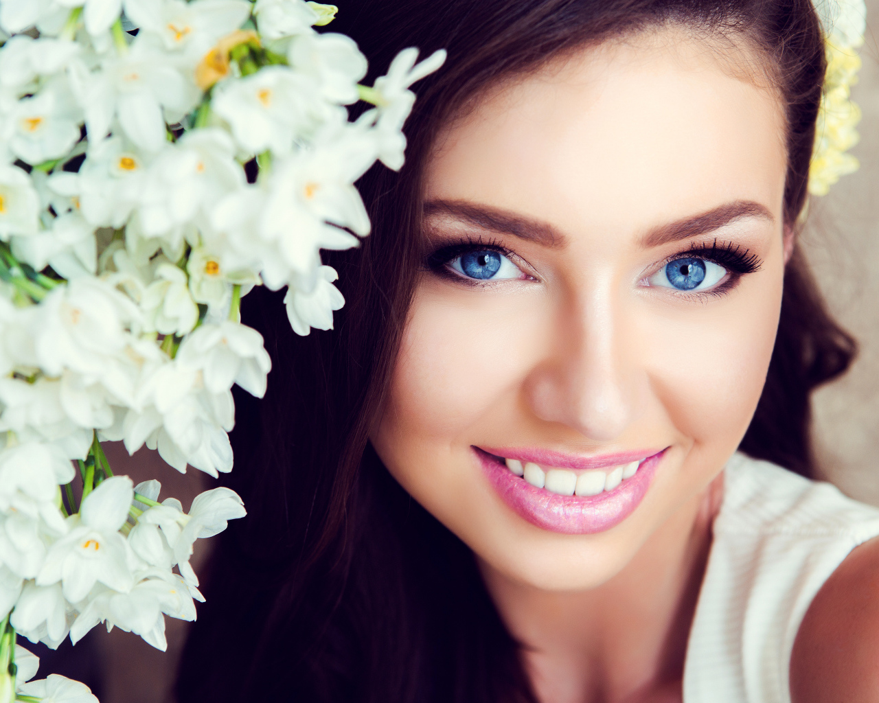Красивая голубоглазая брюнетка с нежными цветами белой орхидеи