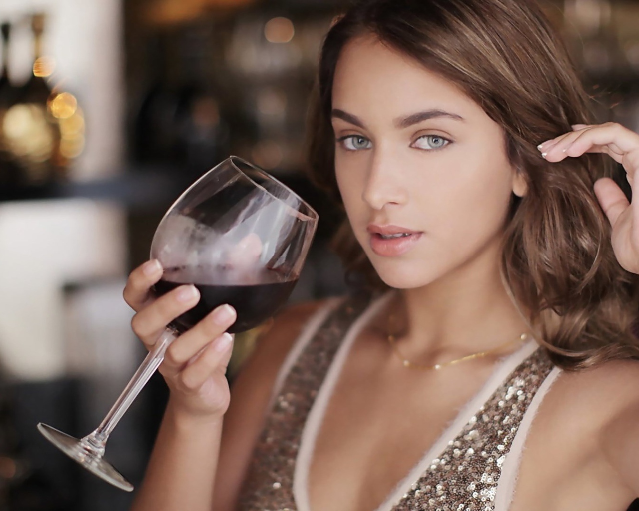 Красивая голубоглазая девушка с бокалом красного вина в руке