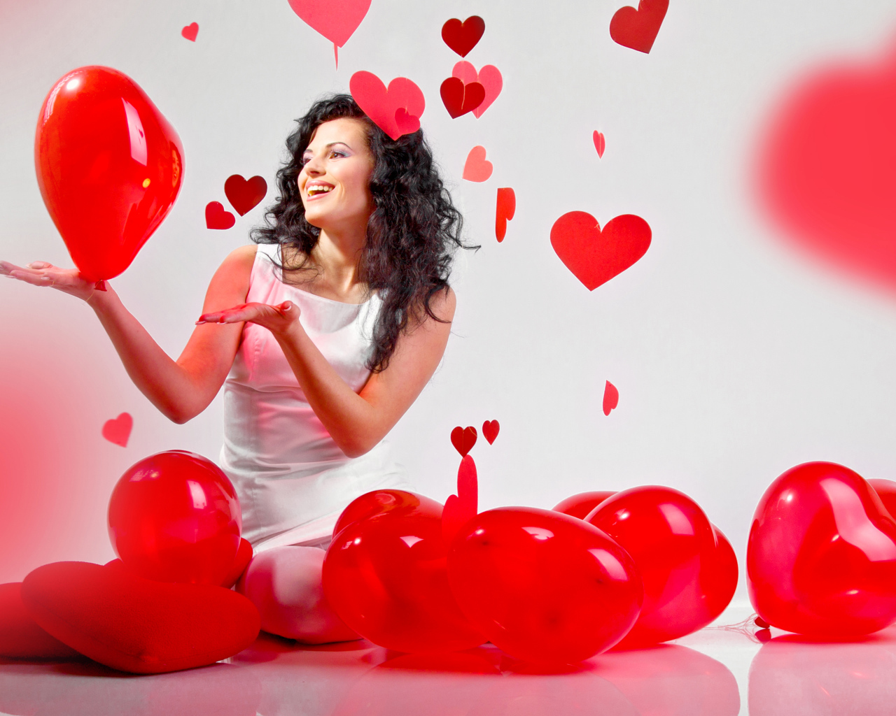 Красивая девушка брюнетка с воздушными шарами в форме сердца