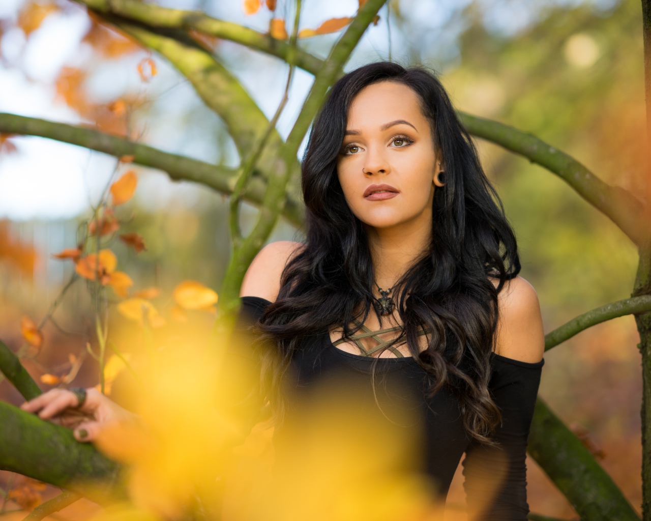 Красивая брюнетка у дерева в черном платье