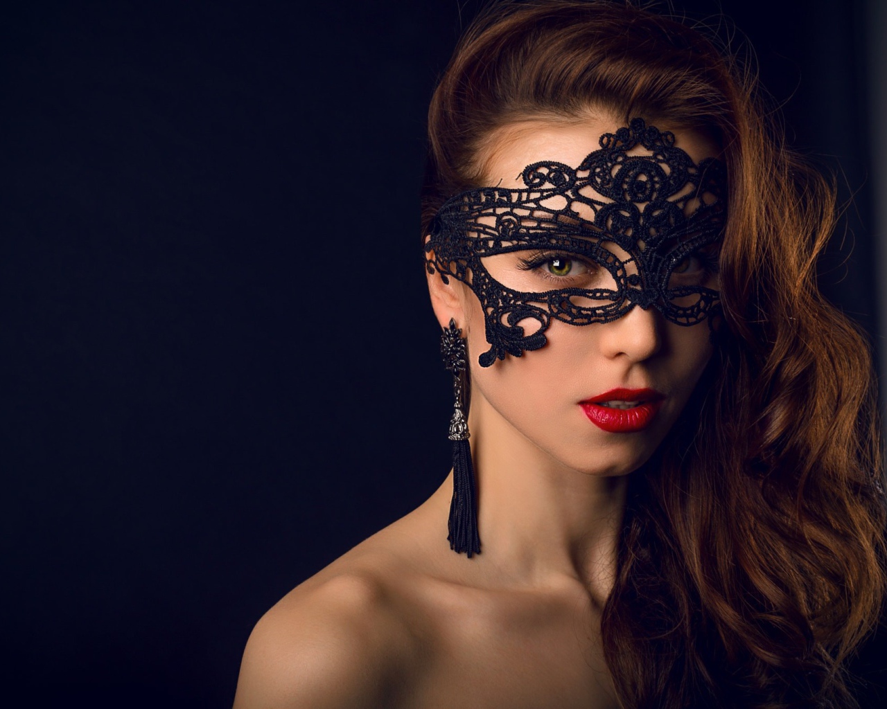 Красивая брюнетка с черной маской на лице 