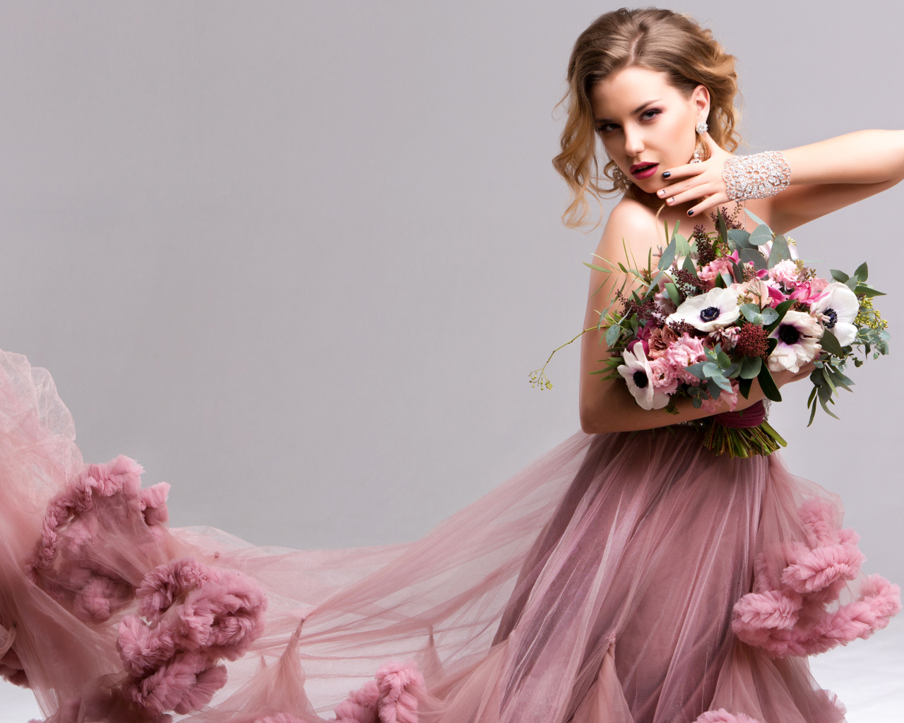 Эффектная девушка в красивом розовом платье с букетом цветов в руках