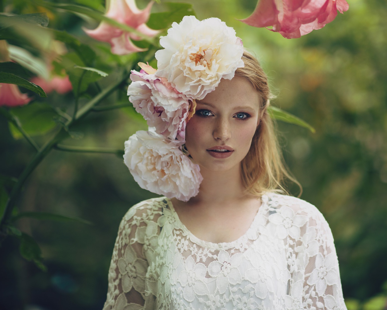 Красивая девушка в белом платье с большими пионами в волосах 