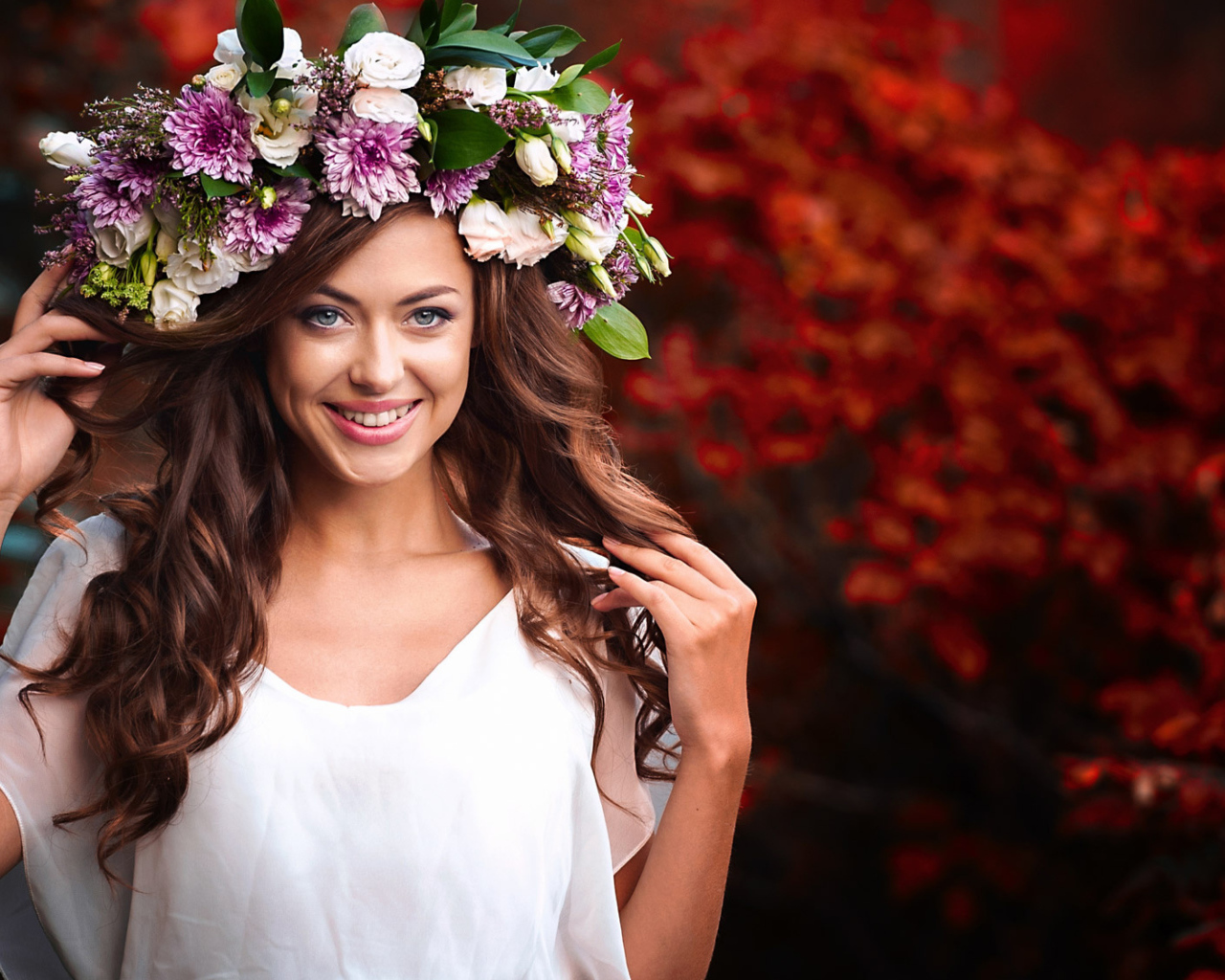 Красивая улыбающаяся девушка с венком из живых цветов на голове 