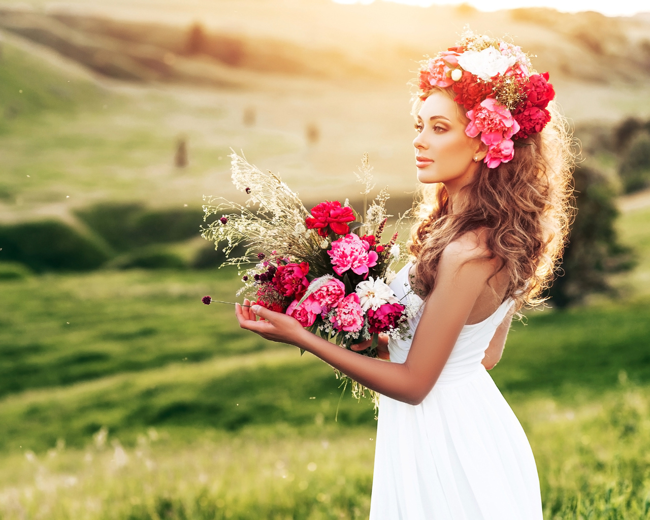 Красивая летняя девушка с букетом цветов и венком на голове