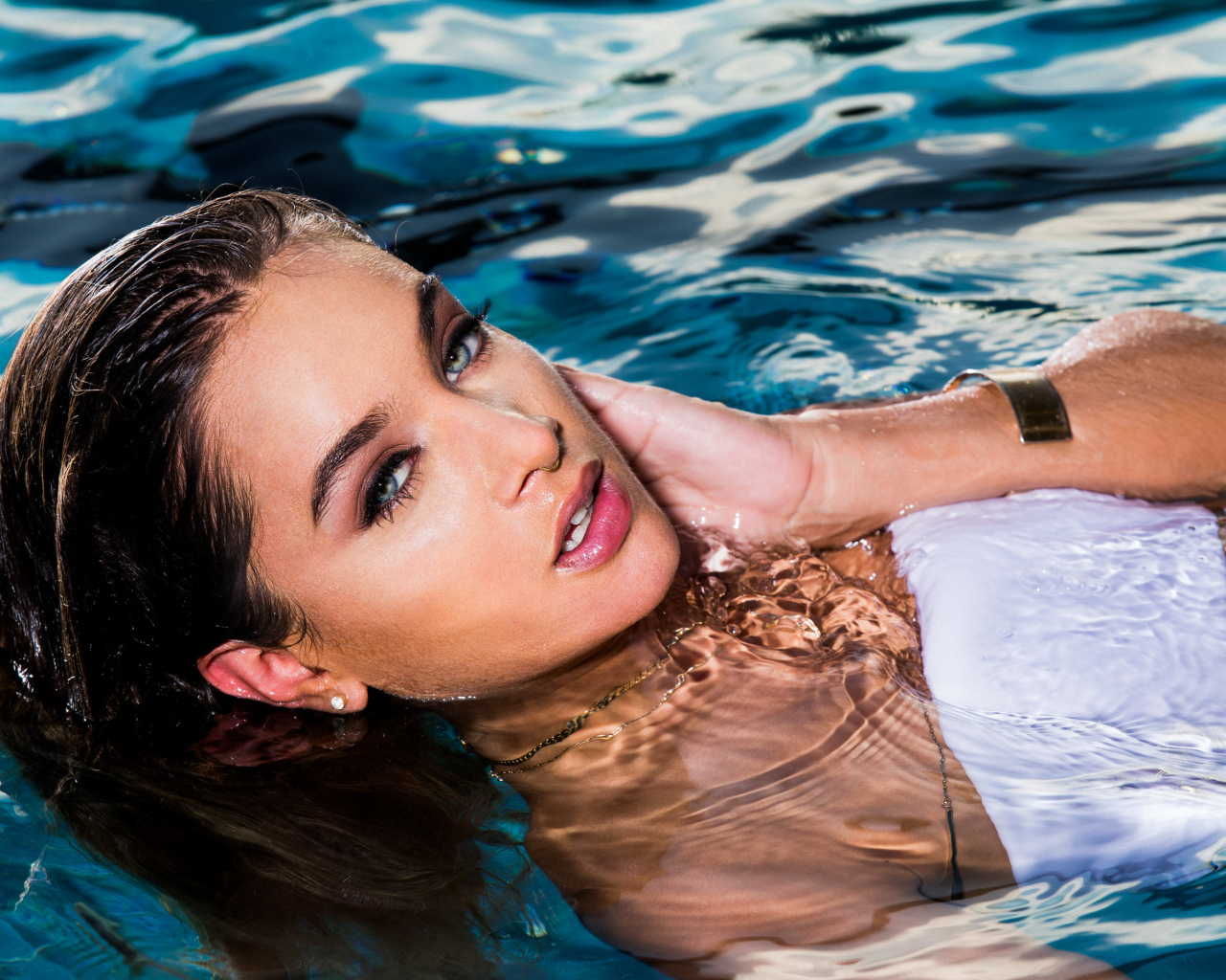 Красивая молодая девушка купается в чистой воде