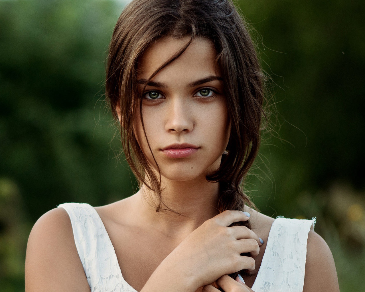 Красивая молодая зеленоглазая девушка с косой на голове