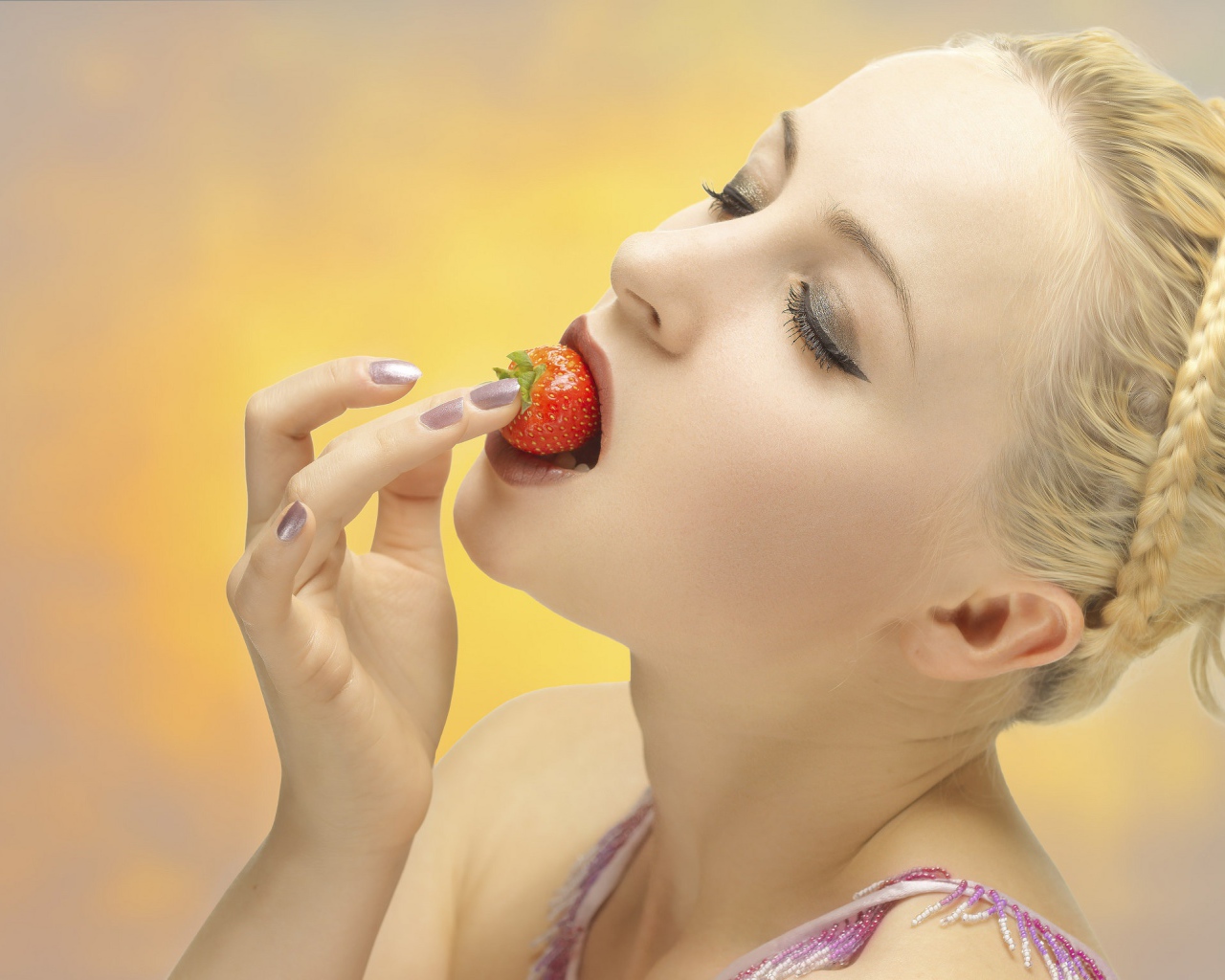 Девушка блондинка ест клубнику