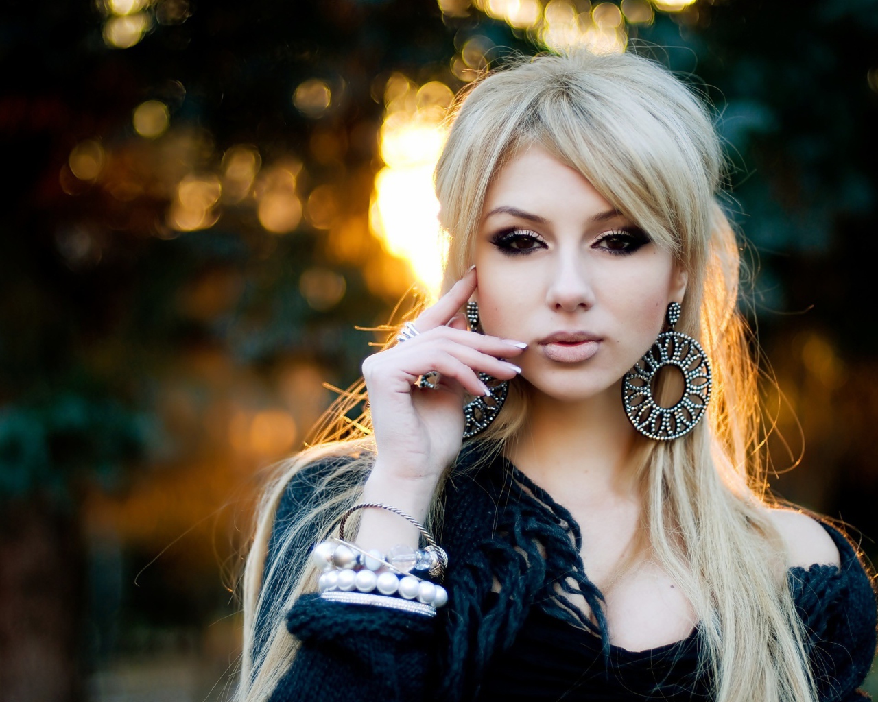 Девушка блондинка с большими серьгами в ушах 