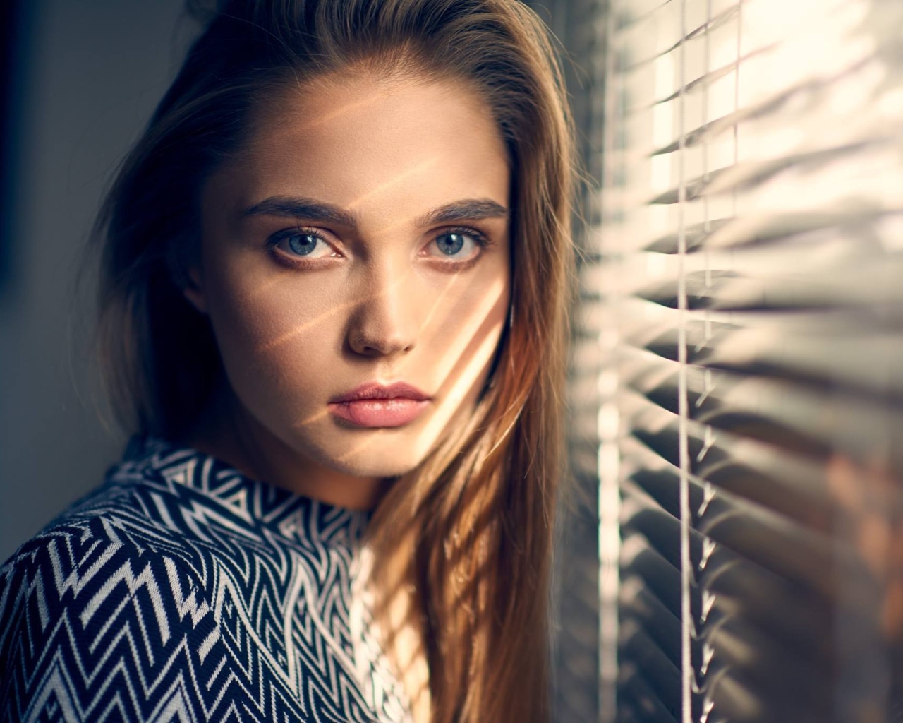 Девушка блондинка с голубыми глазами у окна 