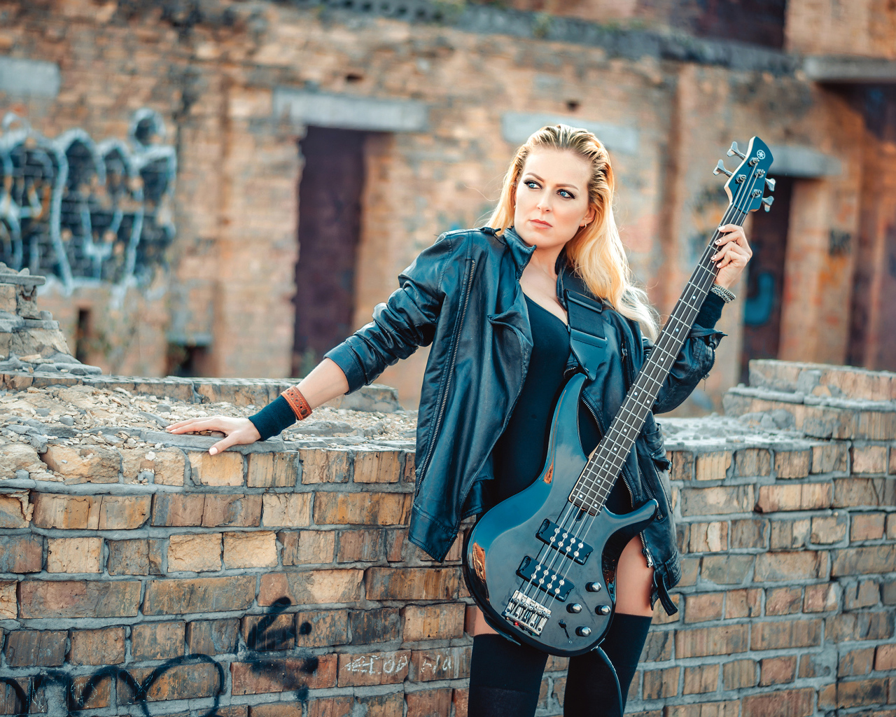 Блондинка в кожаной куртке с электрогитарой в руках