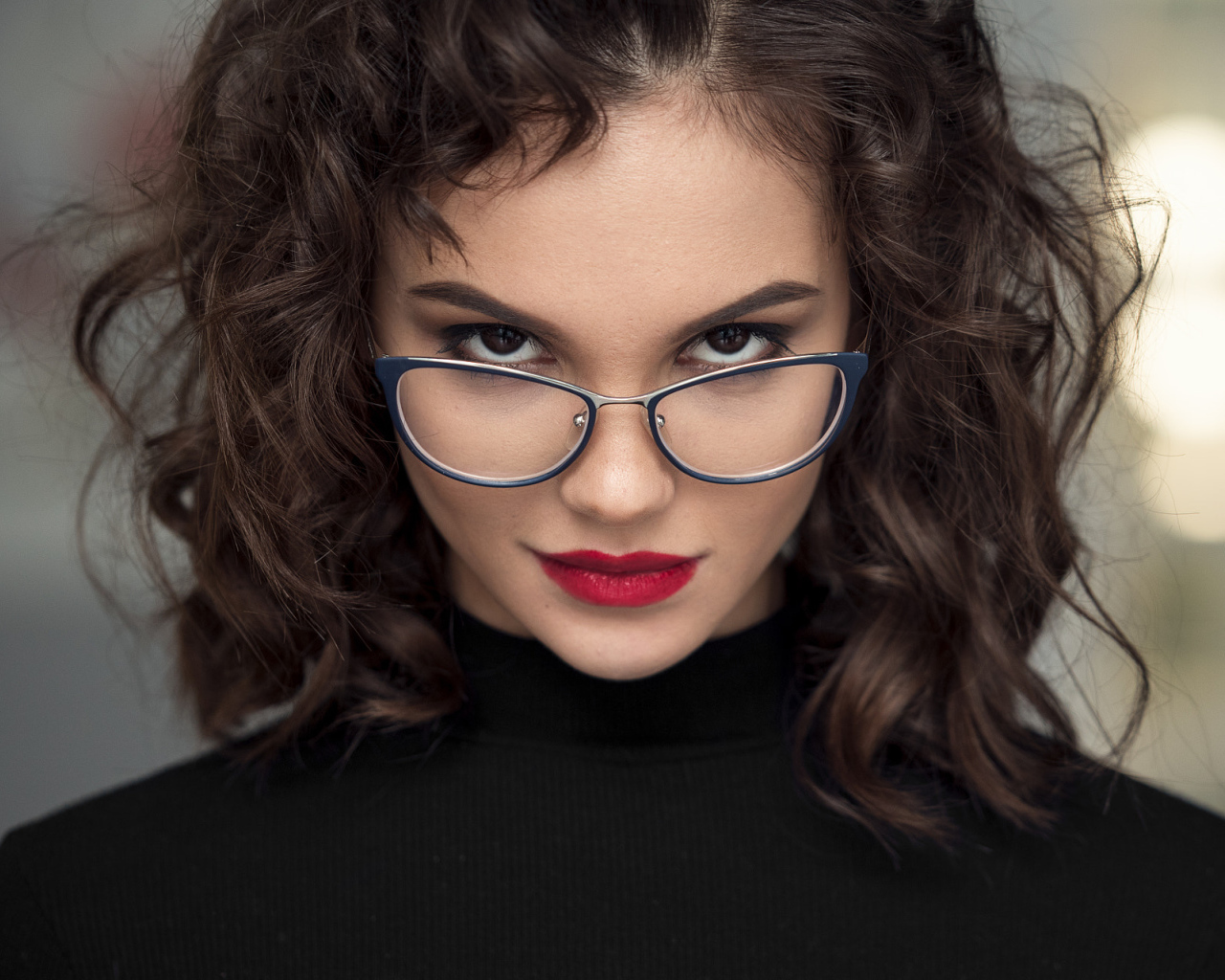 Брюнетка с красными губами с очками на лице