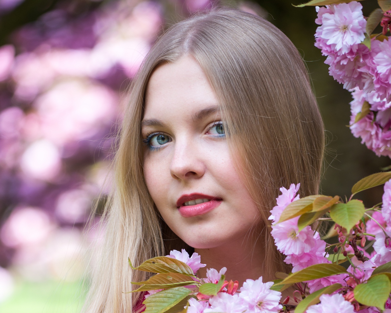 Милая голубоглазая девушка с розовыми цветами 