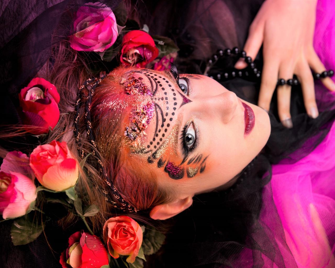 Девушка с блестящим ярким макияжем и розами в волосах