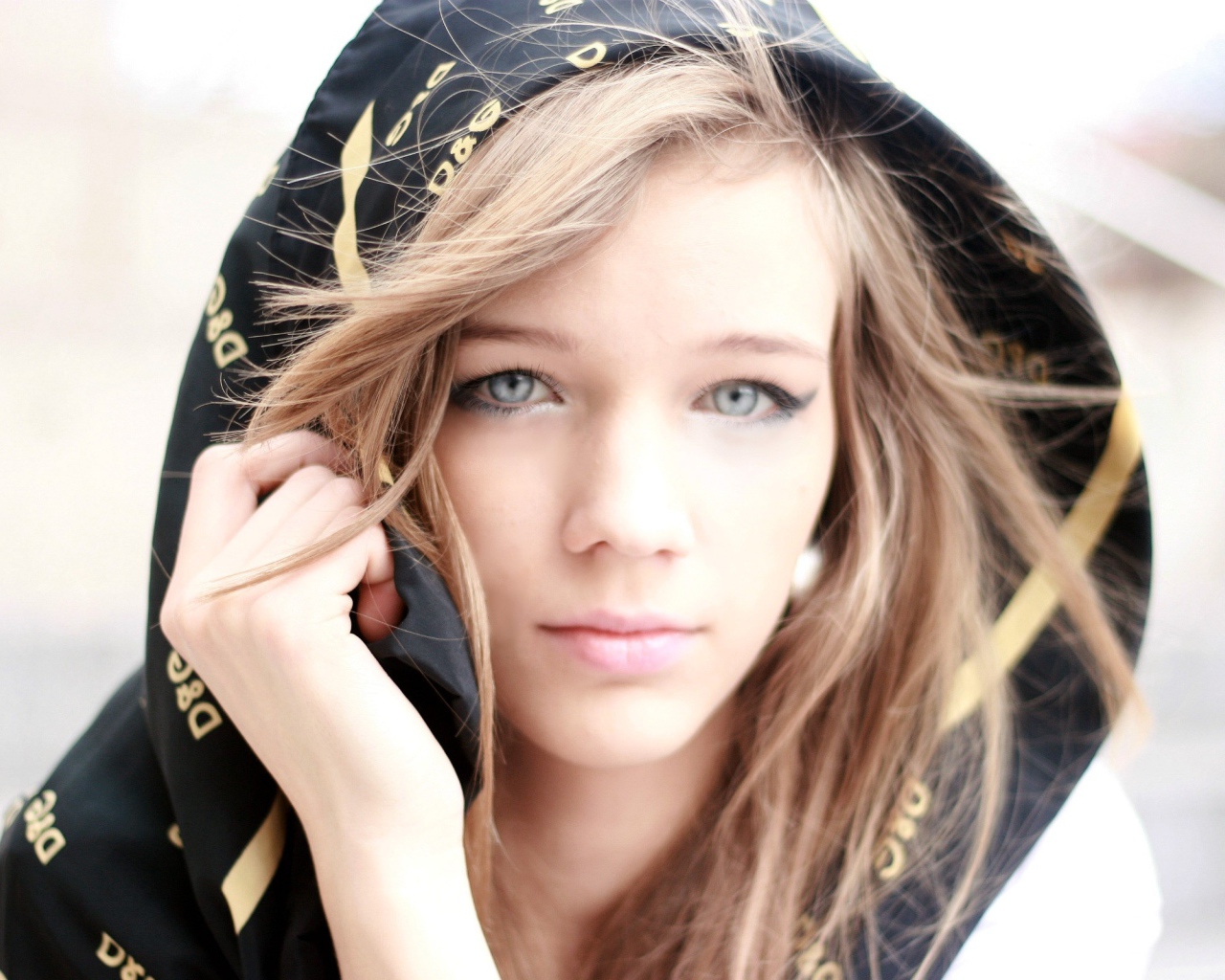 Девушка с голубыми глазами с капюшоном на голове