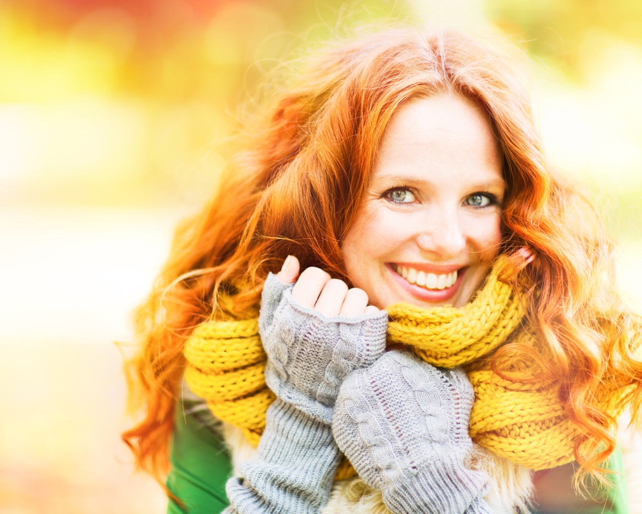 Улыбающаяся рыжеволосая девушка в теплом шарфе