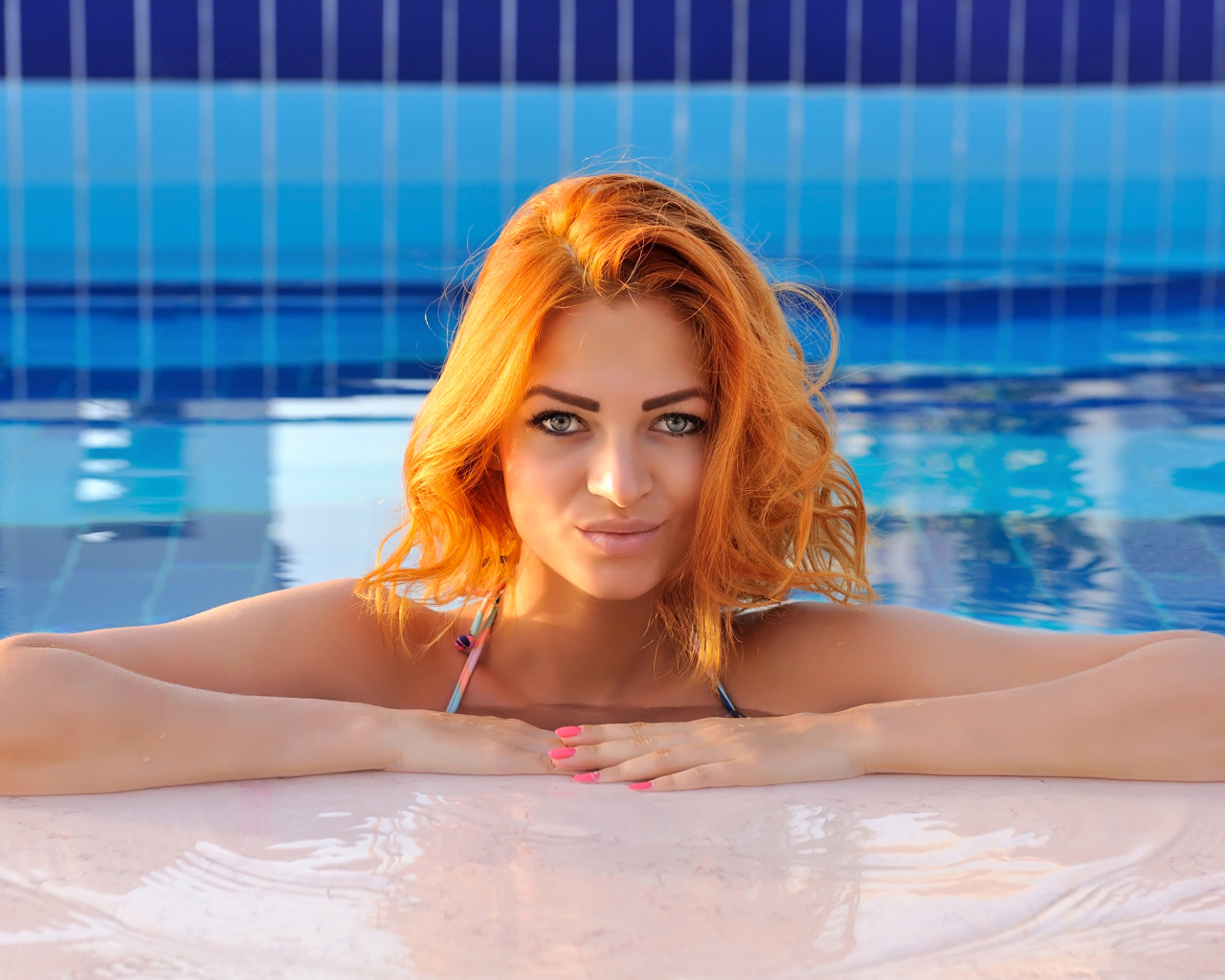 Эффектная рыжеволосая девушка в бассейне