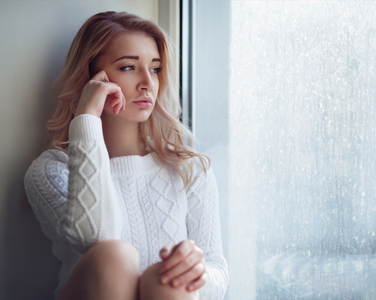 Молодая девушка блондинка у окна 