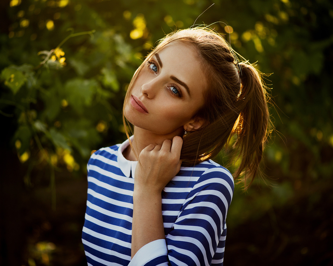 Молодая голубоглазая девушка в полосатом платье