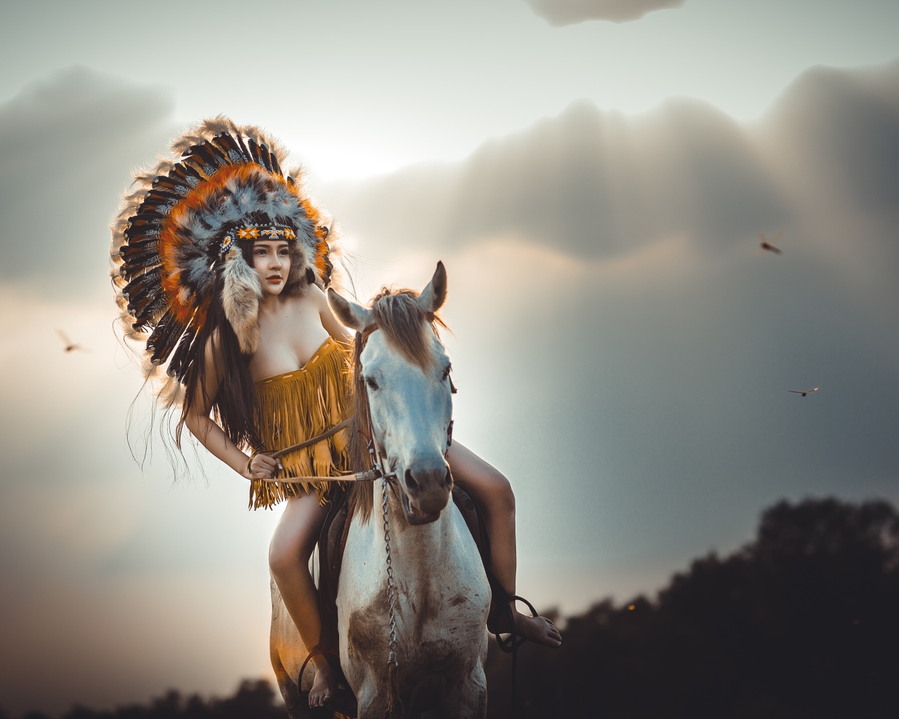 Молодая девушка в костюме индейца на коне