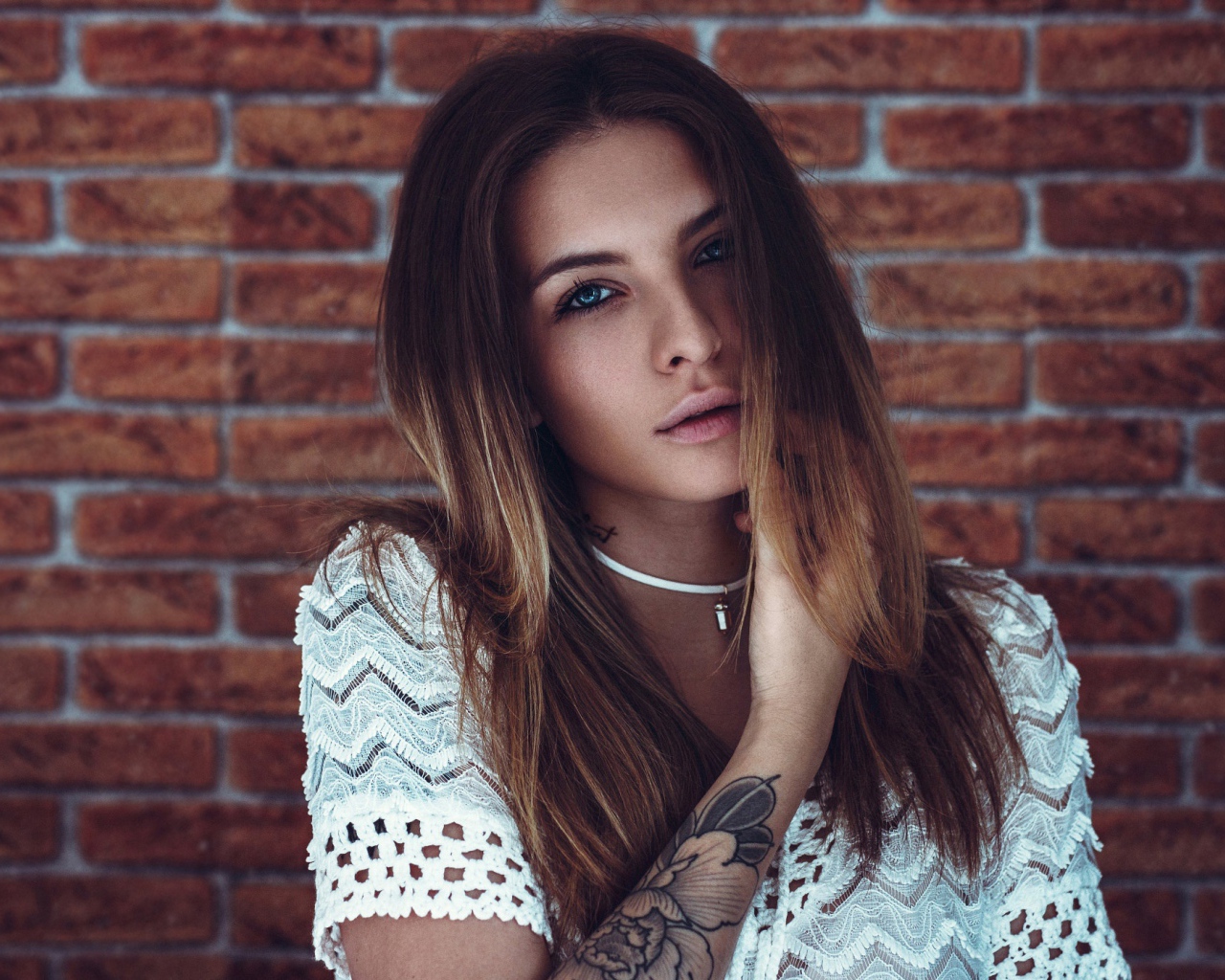 Молодая девушка с татуировкой на руке