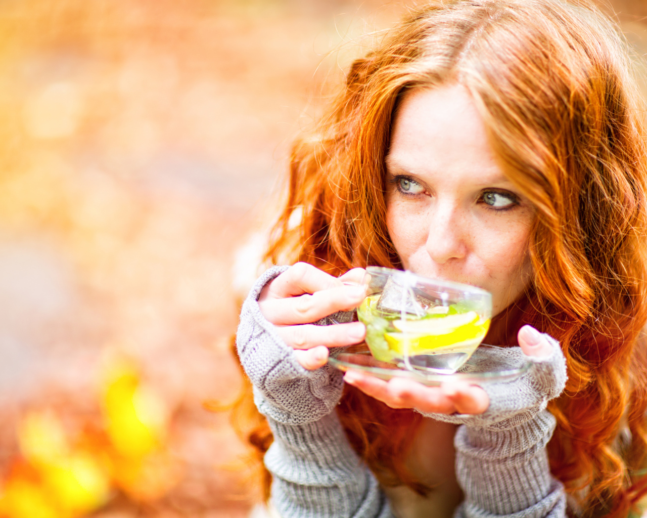 Рыжеволосая девушка модель с чашкой зеленого чая 