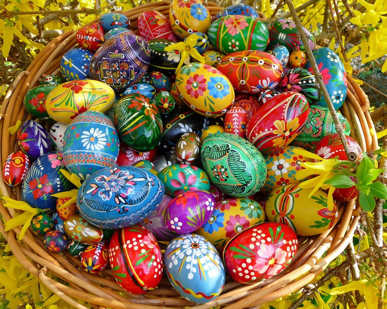 Яркие расписные пасхальные яйца в корзине 