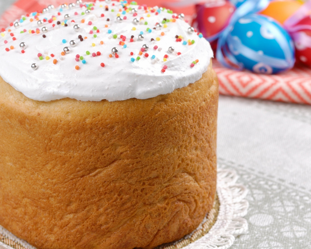 Пасхальный кулич с белой глазурью на столе 