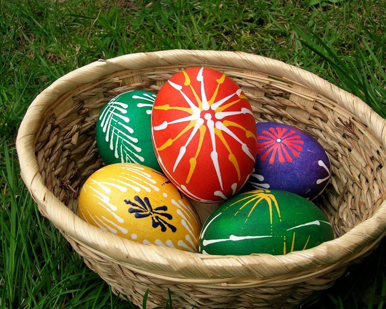 Пасхальные яйца с красивыми узорами в корзине 