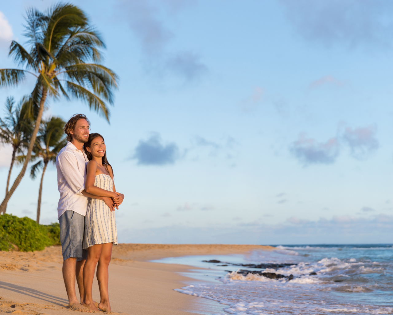 Влюбленная пара встречает закат на берегу океана