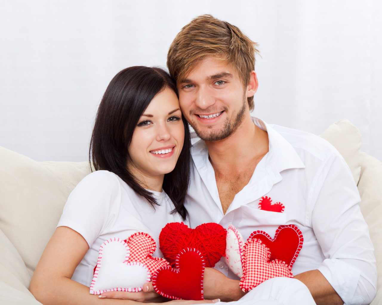 Красивая влюбленная пара с маленькими сердечками в руках