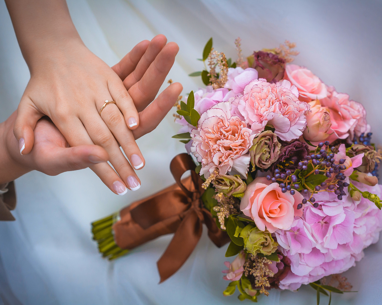 Руки влюбленной пары со свадебный букетов