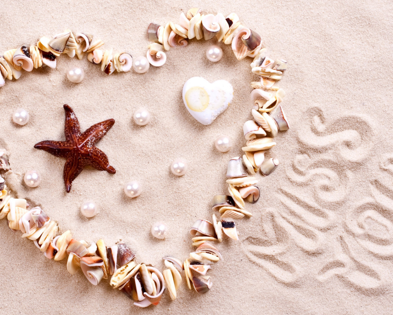 Сердце из ракушек на песке  