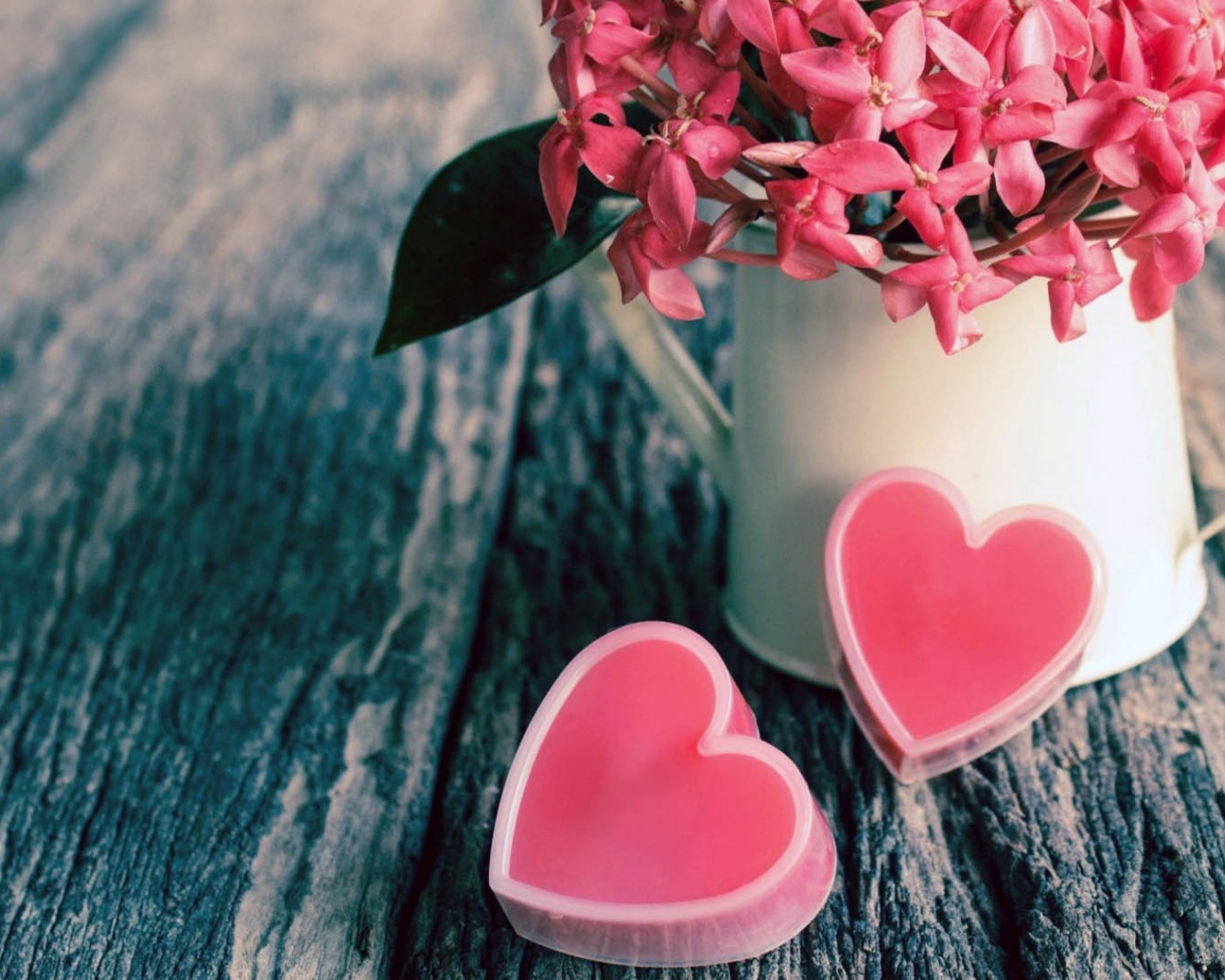 Розовые цветы в белой вазе и два розовых сердца 