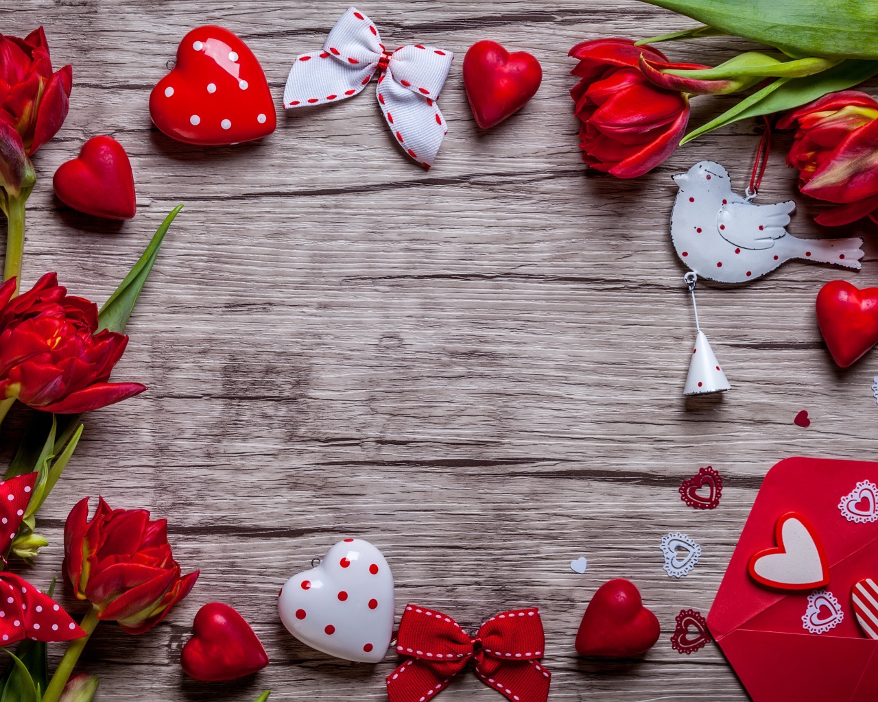Красные тюльпаны с сердечками и бантиками на деревянной поверхности