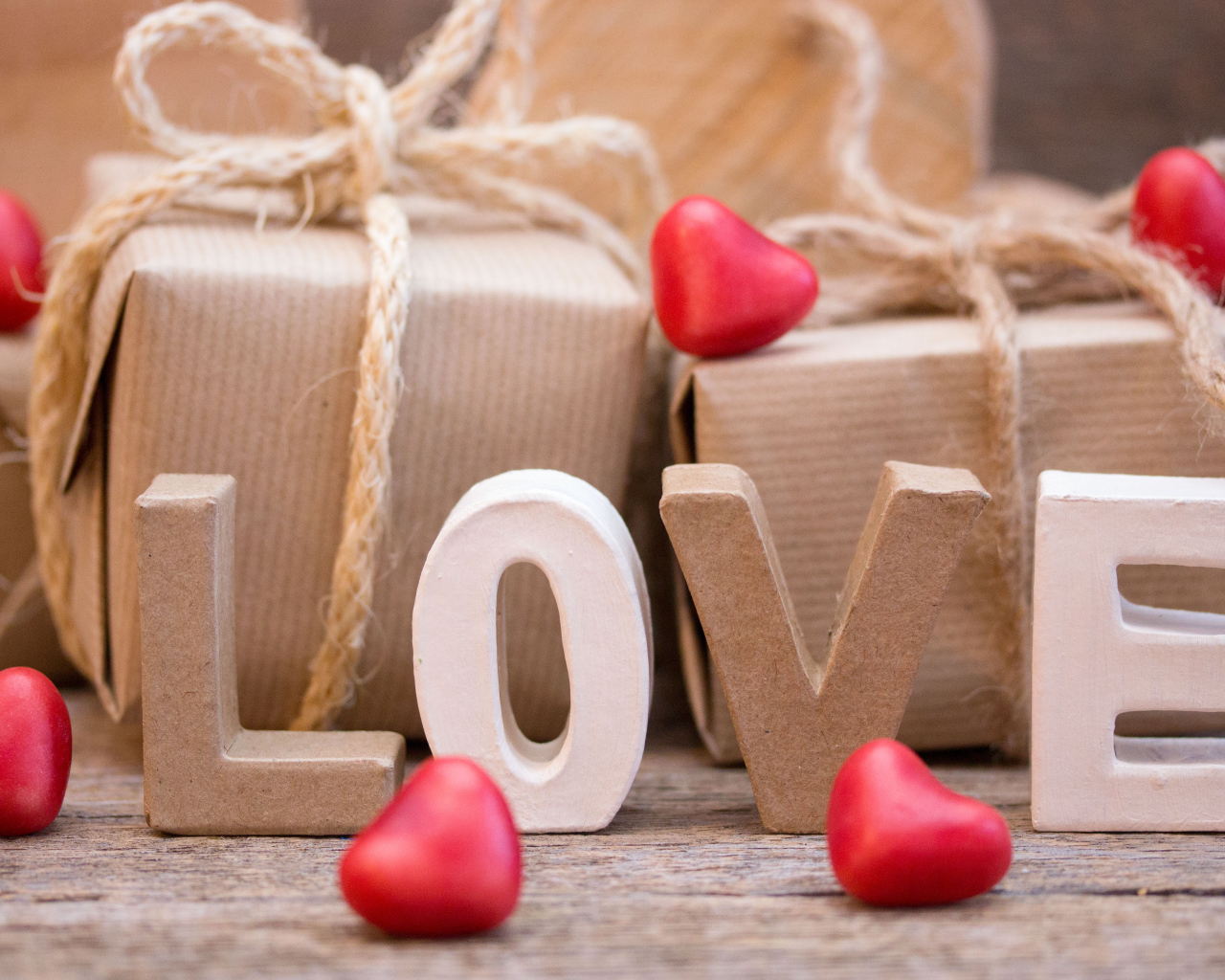 Романтические подарки и надпись Love с красными сердечками