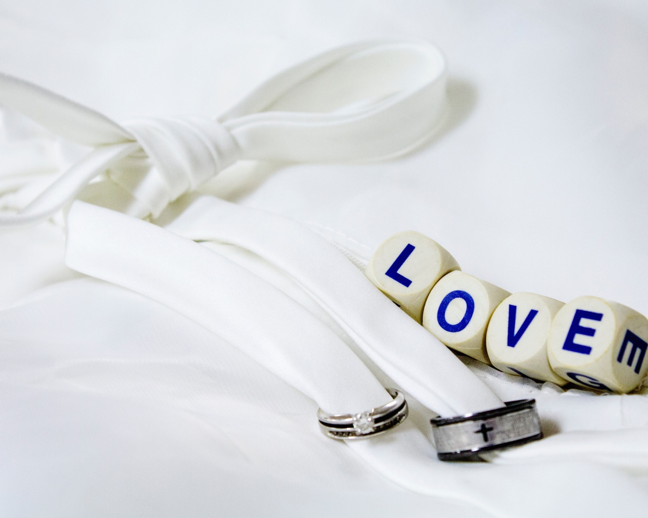 Два кольца перевязанные белой лентой и кубики с надписью любовь
