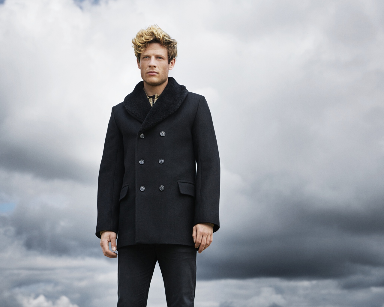 Актер Джеймс Нортон в черном пальто на фоне неба