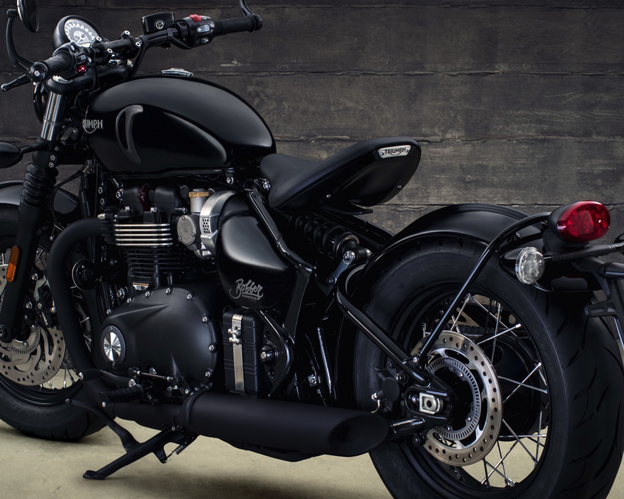 Черный мотоцикл Triumph Bonneville Bobber, 2018 вид сзади