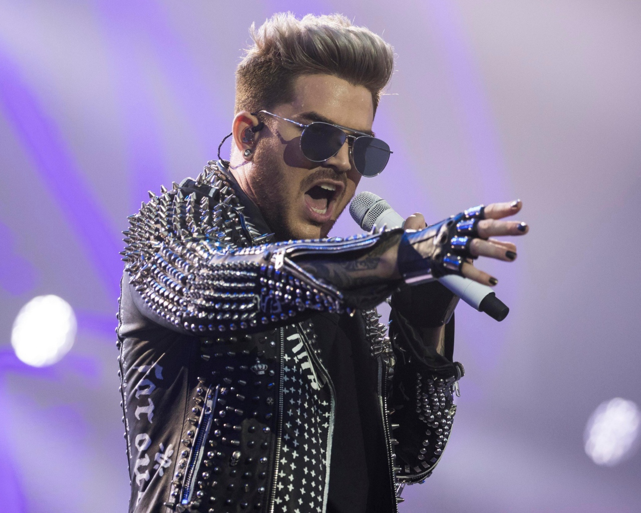 Американский певец Адам Ламберт на сцене с микрофоном