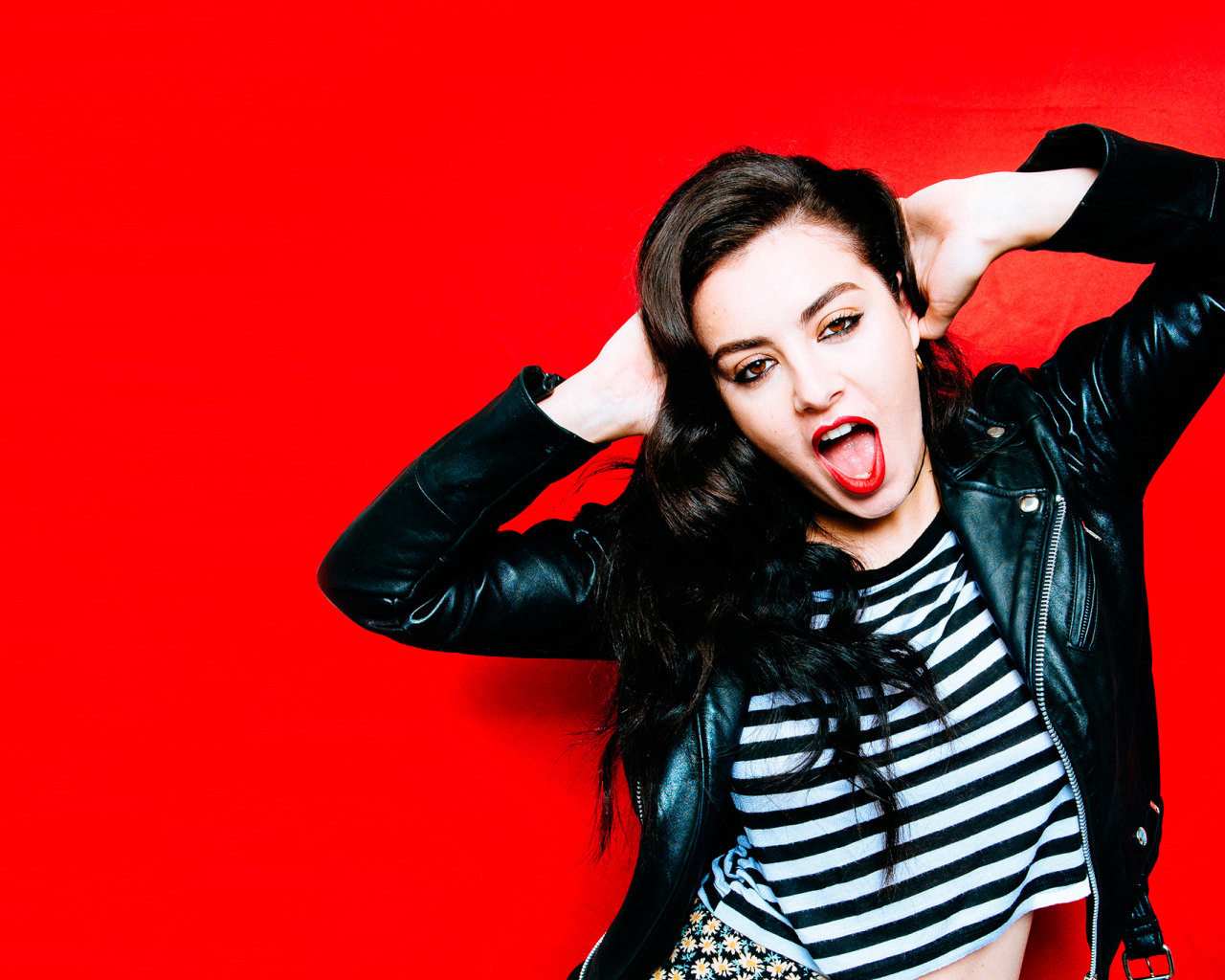 Американская певица Charli XCX позирует на красном фоне 