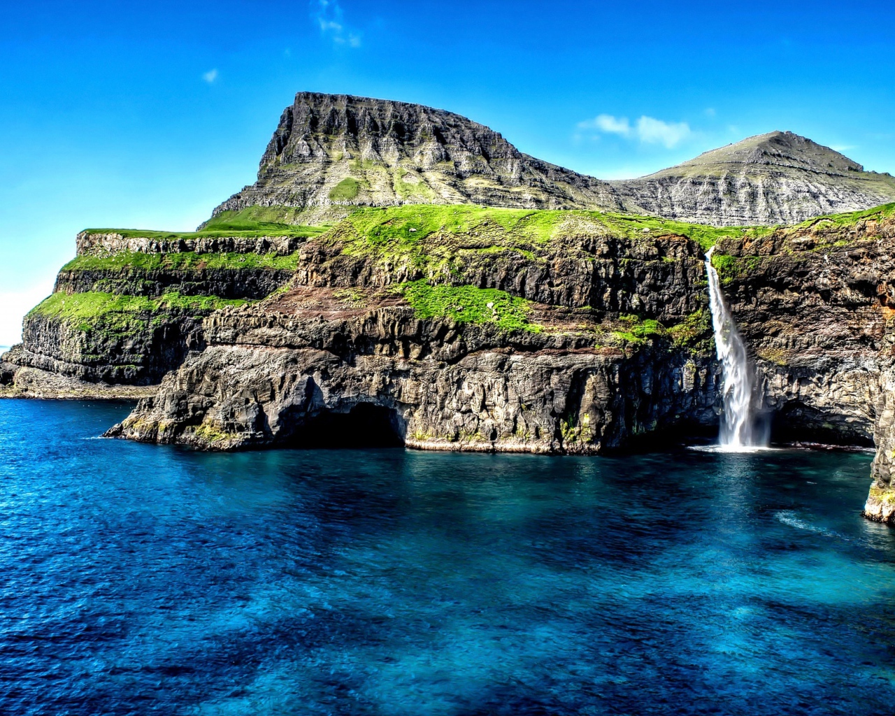 Маленький водопад стекает со скалы в океан, Гавайские острова