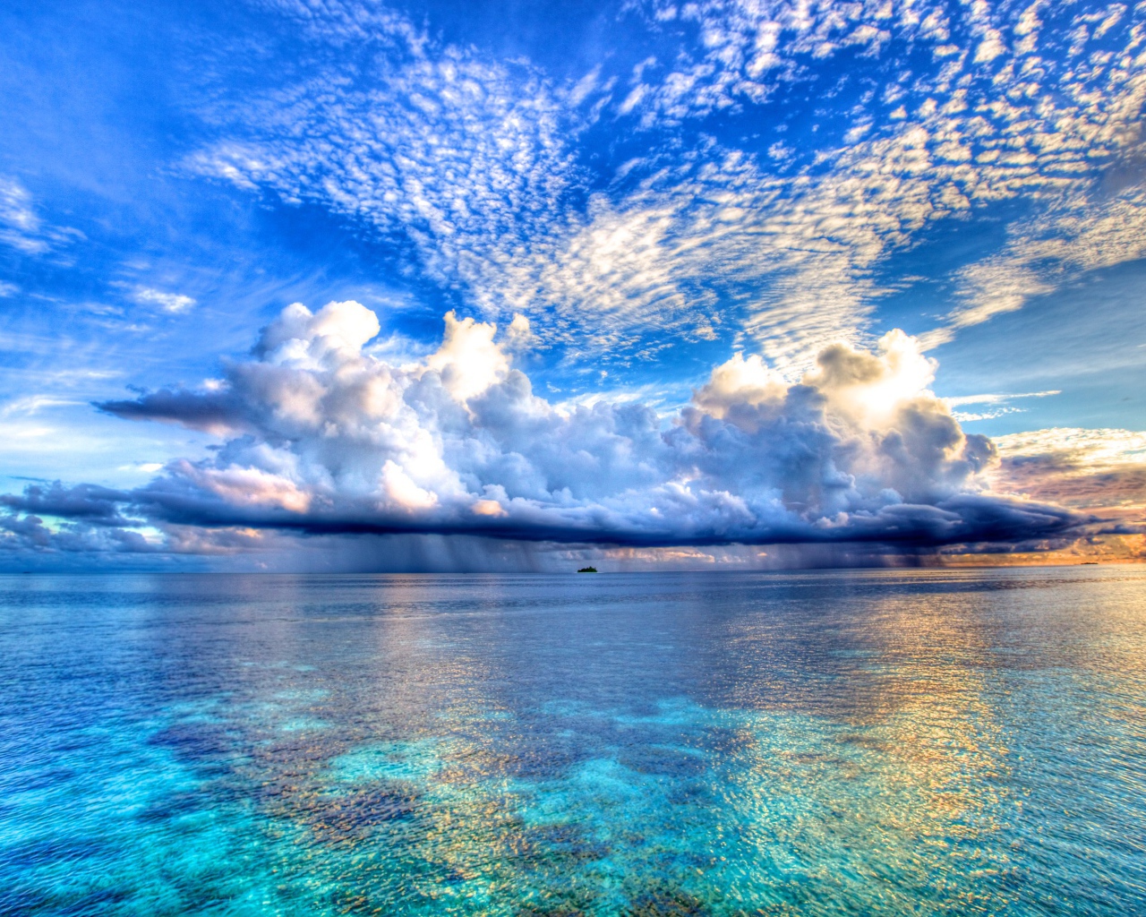 Красивые облака отражаются в голубой воде океана