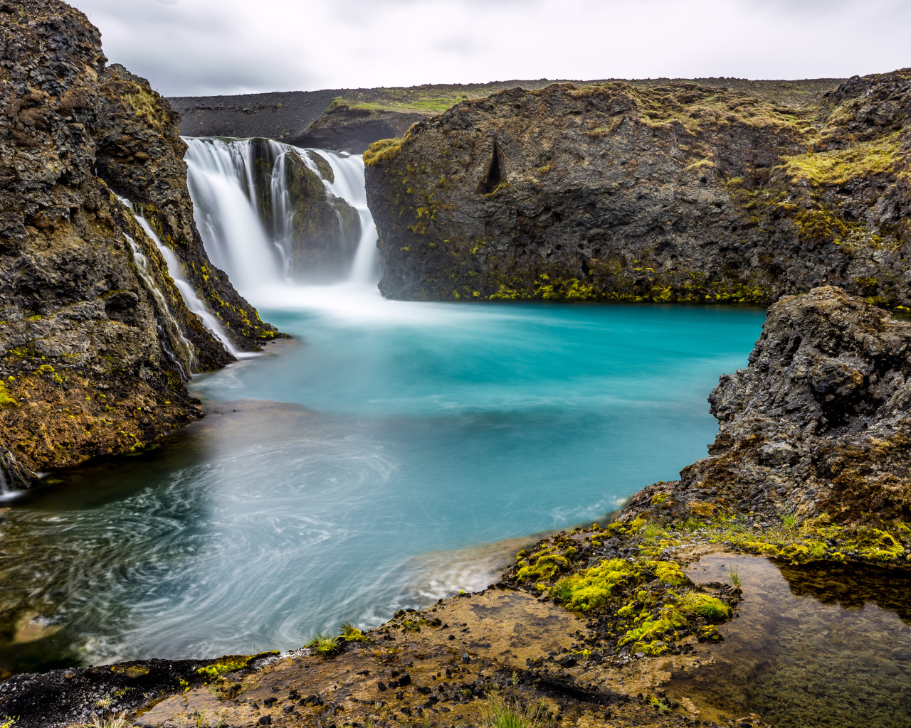 Красивый водопад между скалистых берегов 